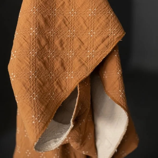 Goldie quilted cotton jacquard fabric in ochre and cream, reversible double-cloth texture, with cream embroidered details.