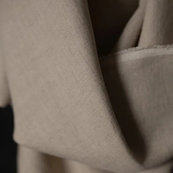 Merchant & Mills 185 European Laundered Linen in Big Sur. A natural coloured dressmaking weight linen. Image is a close up of the cloth draped over the roll.