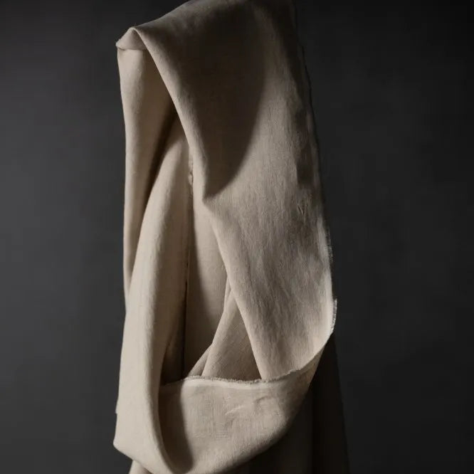Merchant & Mills 185 European Laundered Linen in Big Sur. A natural coloured dressmaking weight linen. Image is of the cloth draped over the roll.
