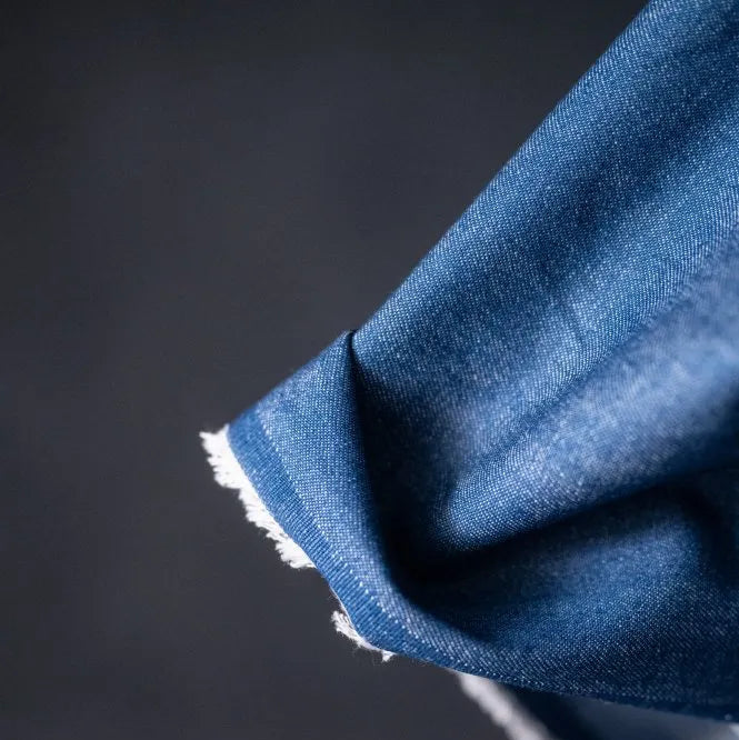 Merchant and Mills 8oz Washed Cotton Denim in Medium. Fabric is draped over bolt and image is a close up of the fabric selvage.