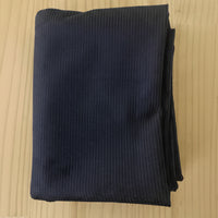 A folded navy 8 wale corduroy in navy, displayed on a light wood grain surface.