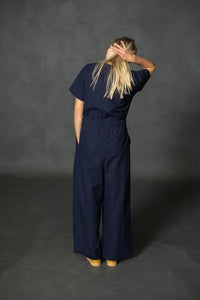 Person wearing a navy blue cassidy jumpsuit against a dark gray background