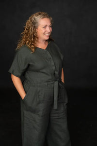 Woman wearing a dark green cassidy jumpsuit against a black background