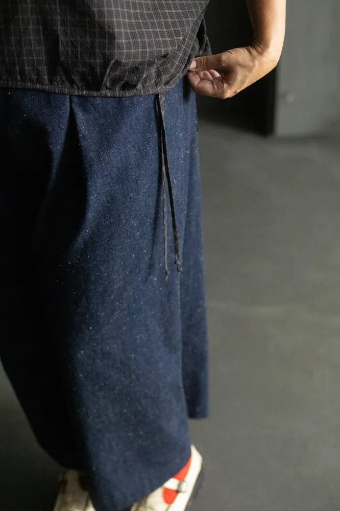 Person wearing a dark checked cirrus top and denim pants on a black background. The Cirrus Top sewing pattern by Merchant and Mills is available at Stitch Piece Loop, Australia.