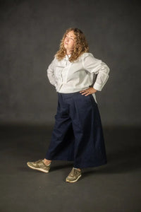 Person wearing a navy pair of Juno Trousers against a dark background. The Juno Trouser sewing pattern is by Merchant and Mills, and available at Stitch Piece Loop, Australia.