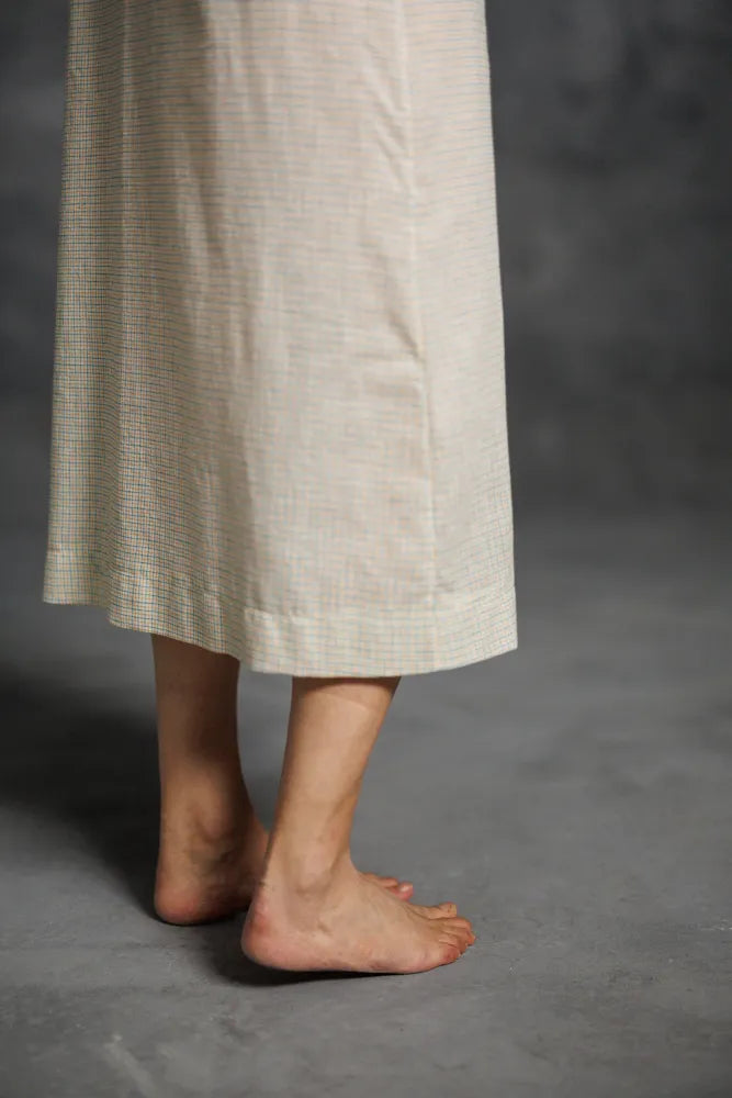 Woman wearing a beige Lilian Slip dress. The Lilian Slip Dress Sewing Pattern by Merchant and Mills available at Stitch Piece Loop Australia
