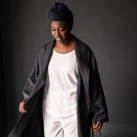 Merchant and Mills European Laundered Linen 185 in Scuttle Black Australia Stitch Piece Loop. The image is of a woman wearing a robe made out of the Scuttle Black linen.