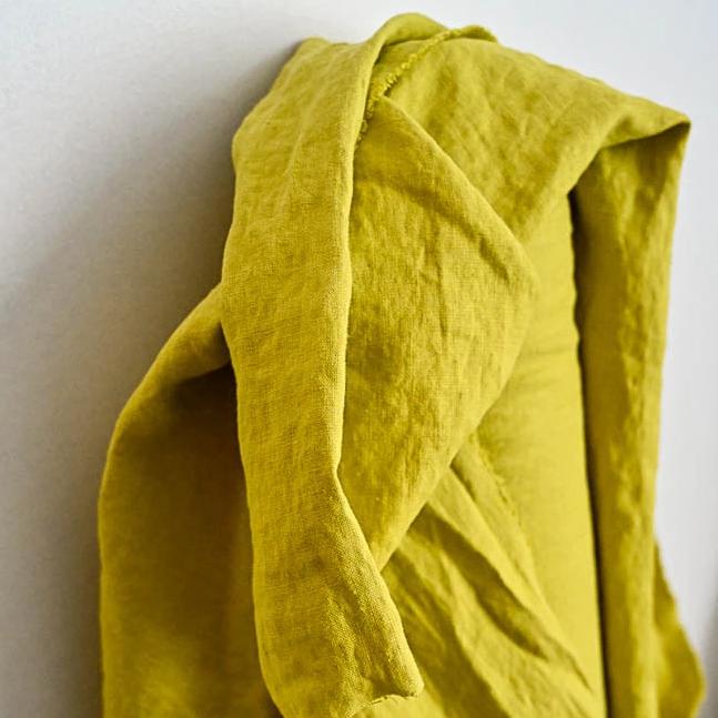 European Laundered Linen 185gsm in Mr Citrus by Merchant & Mills. The image is of the fabric draped over the fabric roll with a light background.  Stitch Piece Loop Australian Fabric Store.