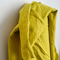 European Laundered Linen 185gsm in Mr Citrus by Merchant & Mills. The image is of the fabric draped over the fabric roll with a light background.  Stitch Piece Loop Australian Fabric Store.
