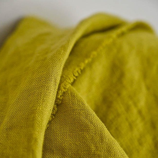 European Laundered Linen 185gsm in Mr Citrus by Merchant & Mills. The image is of the fabric draped over the fabric roll with a light background.  Stitch Piece Loop Australian Fabric Store.
