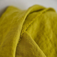 European Laundered Linen 185gsm in Mr Citrus by Merchant & Mills. The image is of the fabric draped over the fabric roll with a light background.  Stitch Piece Loop Australian Fabric Store.